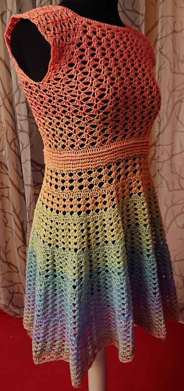 Ärmelloses gehäkeltes Damenkleid in Pastellfarben mit Farbverlauf auf schwarzer Schneiderpuppe