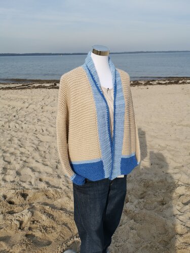Hüftlange offene Strickjacke in Beige mit blauen Kontraststreifen auf einer Schaufensterpuppe