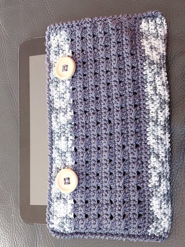 Gehäkelte dunkelblaue Tablet-Hülle mit hellgrauem Rand und zwei Holzknöpfen, Tablet teilweise sichtbar