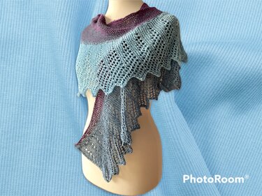 Gestricktes halbrundes Tuch in Bordeaux, Hellblau und Blaugrau mit Lochmuster, auf einer Schaufensterpuppe drapiert.