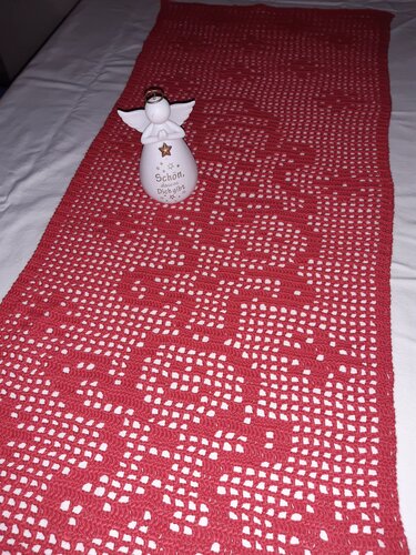 Roter Filet-Häkel-Tischläufer mit durchbrochenem Muster, dekoriert mit einer weißen Engelsfigur für Weihnachten.