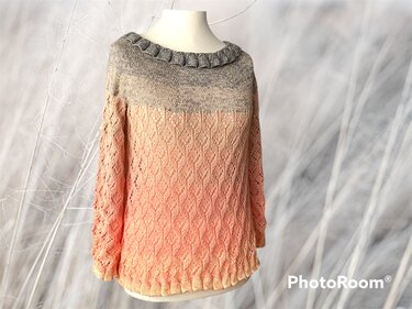 Gestrickter Damenpullover auf einer Schneiderpuppe mit Farbverlauf von Grau zu Rosé und Lochmuster.
