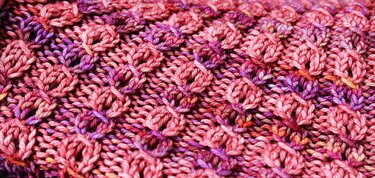 Nahaufnahme gestricktes Muster in Pink- und Violetttönen