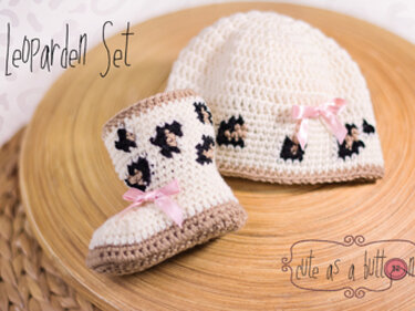 Gehäkelte Babymütze und Booties in Creme mit schwarzen Leopardenflecken und rosa Schleifen
