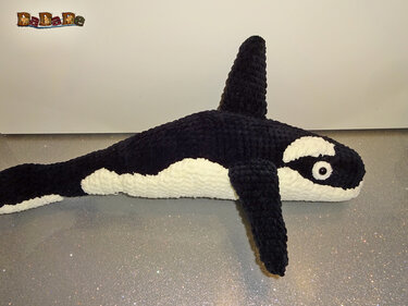 Gehäkelter schwarz-weißer Amigurumi-Orca liegend