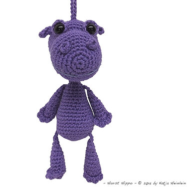 Lila gehäkeltes Amigurumi-Nilpferd mit Schlaufe vor weißem Hintergrund