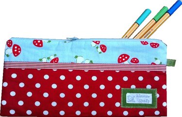 Flaches Reißverschluss-Utensilo mit Pilzmuster oben und rotem Punkte-Stoff unten, mehrere Stifte ragen heraus
