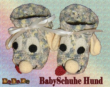 Zwei gehäkelte Babyschuhe in Hundform mit Schleifen
