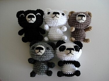 Fünf gehäkelte Amigurumi-Bären in verschiedenen Farben, Nahaufnahme von Proportionen und Gesichtsdetails