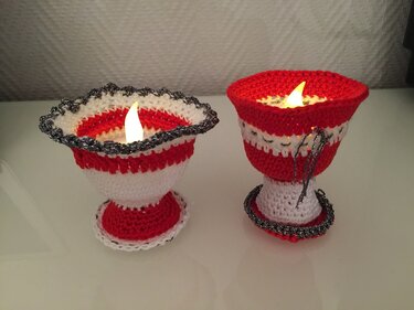 Rote und weiße gehäkelte Teelichthüllen mit breiten Standfüßen und LED-Teelicht