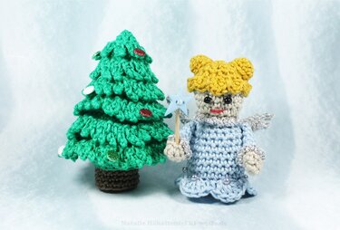 Gehäkelter Weihnachtsbaum mit Pailletten und Amigurumi-Engel mit Sternstab vor hellem Hintergrund.