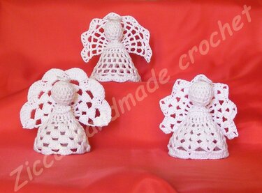 Three small white crochet angels with different wing patterns on red background