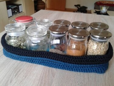 Blaues gehäkeltes Aufbewahrungs-Tablett mit kleinen Glasbehältern