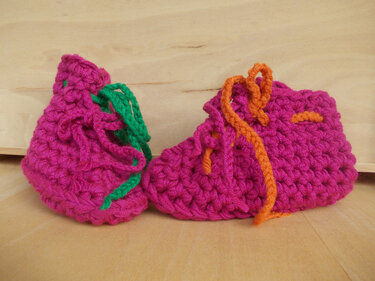 Pinke gehäkelte Babyschuhe mit orange-grünem Schnürband, Detailansicht