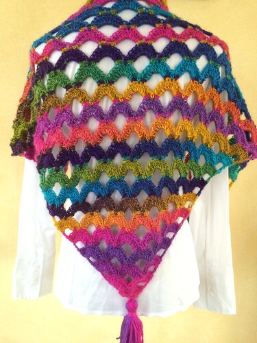 Buntes gehäkeltes Dreieckstuch mit Muschelmuster und Quaste über weißer Bluse