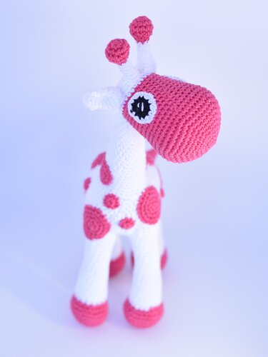 Weiß-rosa gehäkelte Amigurumi-Giraffe mit rosa Flecken und großer Schnauze