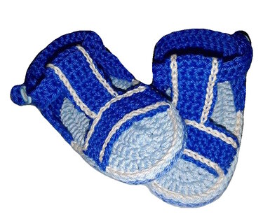 Blaues Paar gehäkelter Babyschuhe mit Spannriemen und kontrastierender weißer Naht