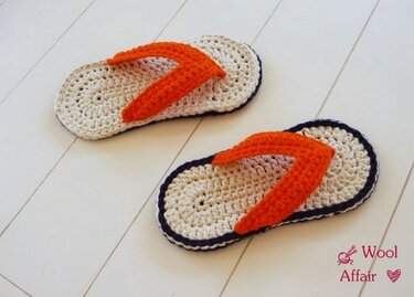 Gehäkelte Flip‑Flop‑Hausschuhe mit beiger Sohle, dunkler Kante und orangefarbenem Riemen
