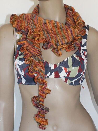 Nahaufnahme eines mehrfarbigen, gestrickten Tuchs mit Rüschensaum an einem Mannequin