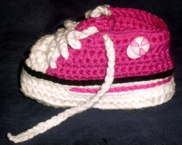 Rosa-weißer gehäkelter Babyschuh im Sneaker‑Stil mit Kordel und seitlichem Knopf
