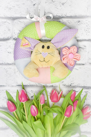 Genähter Osterkranz in Pastellfarben mit Hasengesicht, langen Ohren, kleiner Schleife und Stoffblume zum Aufhängen