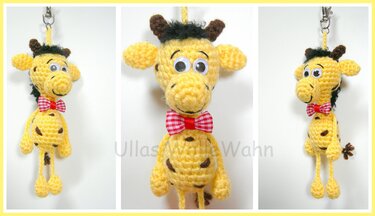 Gehäkelter gelber Giraffen‑Schlüsselanhänger mit Wackelaugen und rot-weiß kariertem Schleifchen, Vorderansicht