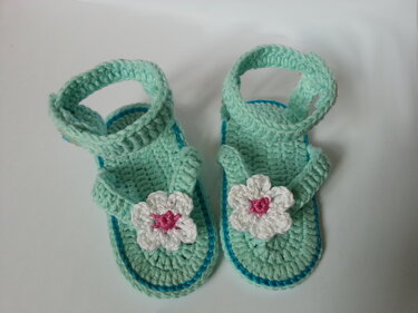 Gehäkelte mintgrüne Babysandalen mit weißen Blüten und rosa Mitte, Draufsicht