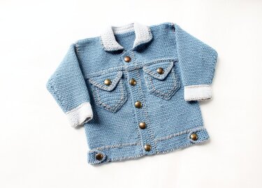 Light blue crocheted baby jacket with light grey collar and cuffs, flap pockets and round metal buttons