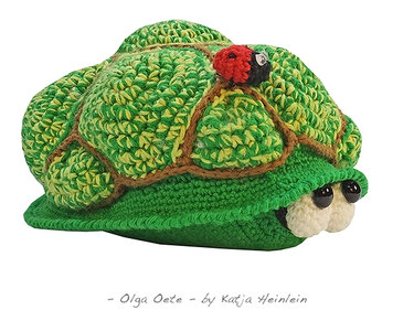 Gehäkelte grün-gelbe Schildkröte mit kleinem Marienkäfer auf weißem Hintergrund