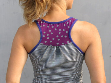 Rückenansicht eines Racerback-Tops mit grauen Streifen, violettem Rückeneinsatz und hellen Punkten