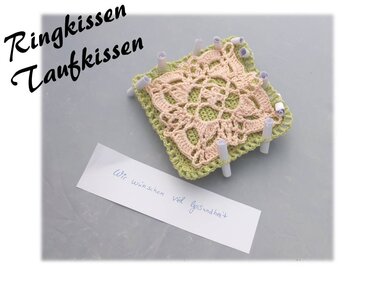 Gehäkeltes Quadrat in Grün und Rosa auf Blockierunterlage, gespannt zum Trocknen.