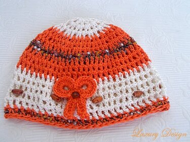 Gehäkelte Mütze in Orange und Weiß mit Schleife und Perlen