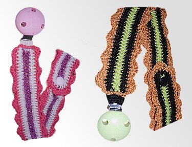 Zwei gestreifte, gehäkelte Schnullerbänder mit Rüschenkante und Metallclips