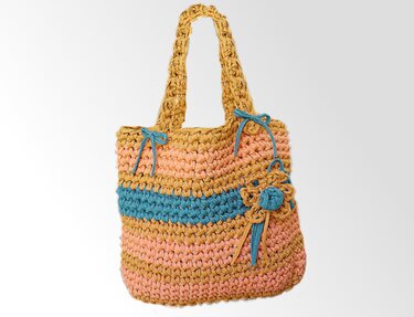 Gehäkelte Henkeltasche in Sand-, Rosé- und Türkistönen mit Streifen, Schleifen und Blumenapplikation