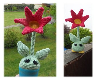 Handgehäkelte rote Blume mit gelbem Zentrum, grünem Stängel, Blättern und Gesicht im kleinen Topf