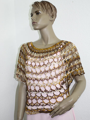 Mannequin trägt gehäkeltes Kurzarm-Top mit offenem Muschelmuster in Braun und Gold über hellem Untertop