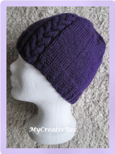 Violette gestrickte Mütze mit Zopfdetail auf Schaufensterkopf