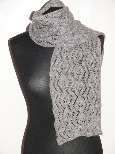 Grau gestrickter Schal mit feinem Blatt-Lochmuster auf schwarzer Schneiderpuppe