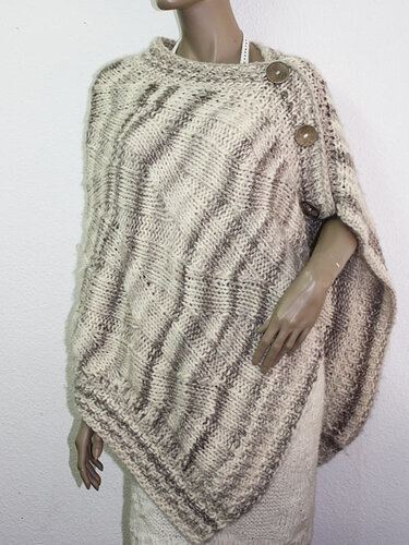 Beiger, melierter Poncho mit markanter Maschenstruktur und drei Schulterknöpfen an einer Schaufensterpuppe