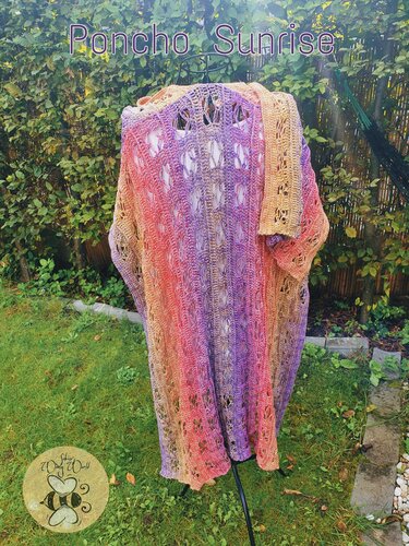 Gehäkelter Damenponcho mit Farbverlauf von Orange zu Violett auf Ständer im Garten
