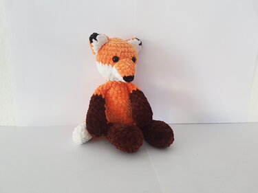 gehäkelter Amigurumi-Fuchs sitzend in Orange, Braun und Weiß