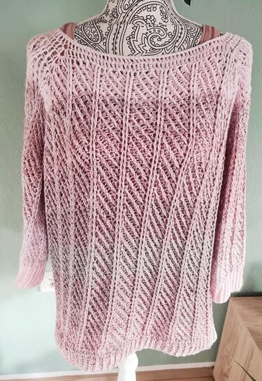Rosafarbener Damenpullover mit diagonalem Ajourmuster auf einer Schneiderpuppe