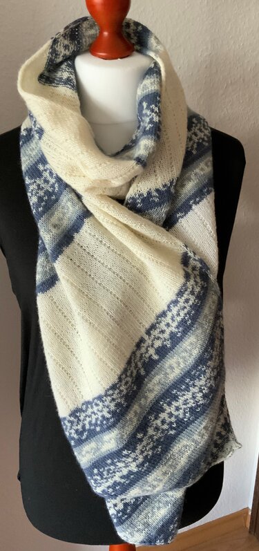 Gestrickter creme-blauer Schal mit Streifen- und Norwegermuster auf schwarzer Schaufensterpuppe