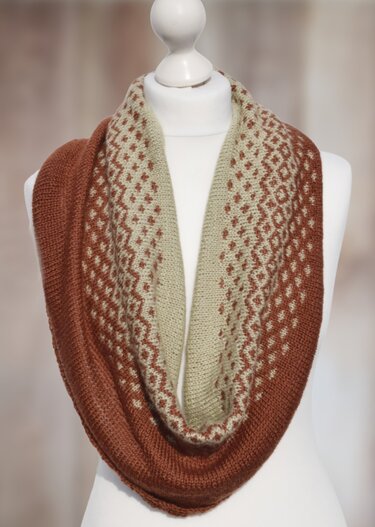 Gestrickter Loop-Schal in Rostbraun und Beige mit Fair-Isle-Muster auf einer Schaufensterpuppe