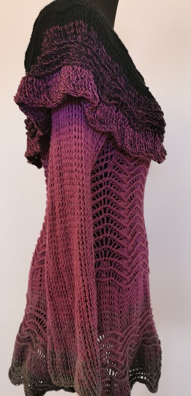 Gehäkelter Longpullover mit Ombre-Farbverlauf von Schwarz zu Lila, mit Rüschen und Zackenmuster.