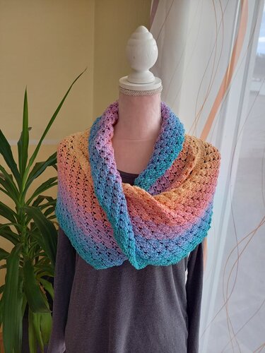 Gehäkelter Loop in Pastell‑Regenbogenfarben auf Schneiderpuppe