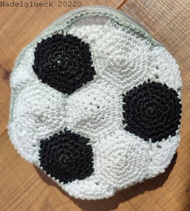 Rundes gehäkeltes Täschchen in Weiß mit schwarzen kreisförmigen Einsätzen und Reißverschluss