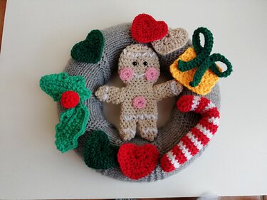 Weihnachtskranz mit gehäkeltem Lebkuchenmann, Herzen, Zuckerstange und Geschenk