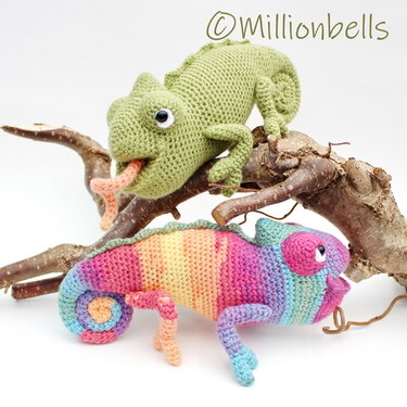 Two crocheted chameleons: a green one on a branch with its tongue out and a rainbow-striped one with a curled tail.