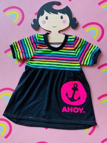Kinderkleid mit neonfarben gestreiftem Oberteil und schwarzem Rock, pinker Anker mit Schriftzug ",AHOY" als Plottmotiv